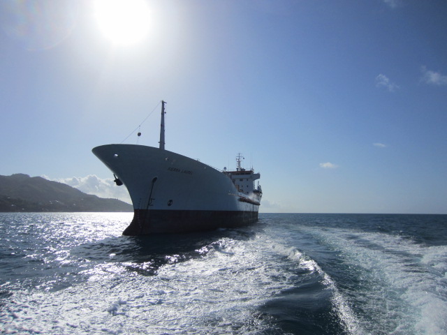 An image of a ship at sea with the sun overhead