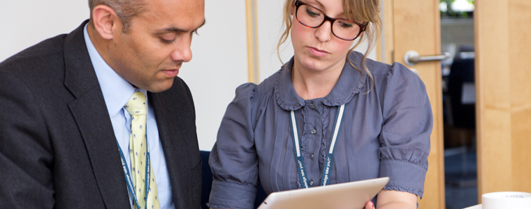 Man and woman reviewing content on a tablet