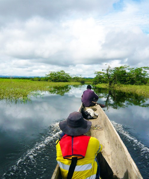 BMT environmental engineers in a canoe on a river in Papua New Guinea