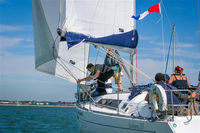 A sailing yacht on the water with a crew of people
