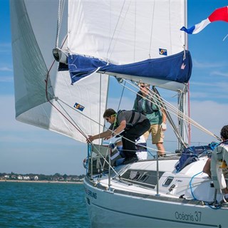 A sailing yacht on the water with a crew of people