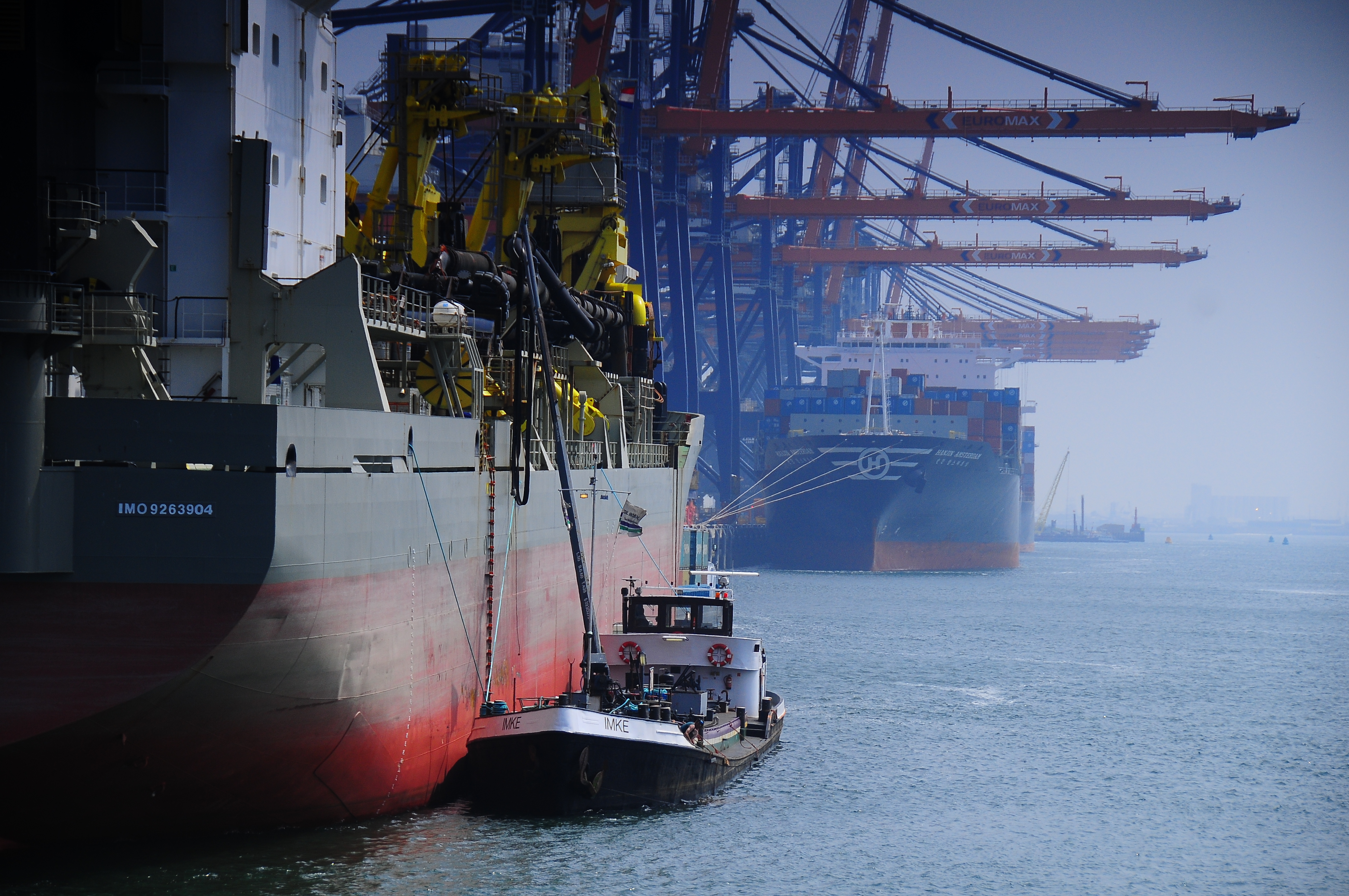 A tug boat alongside a larger vessel in a harbour