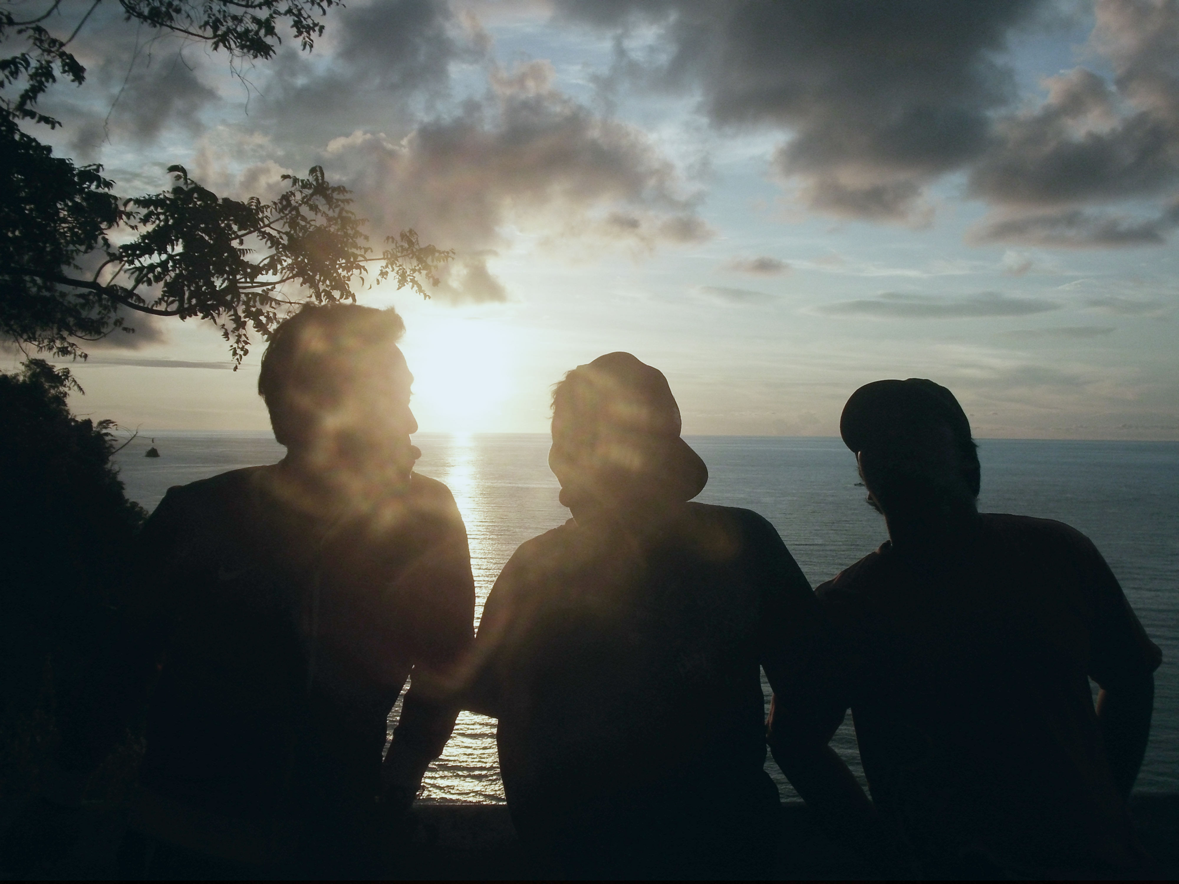 Three people talking at sunset