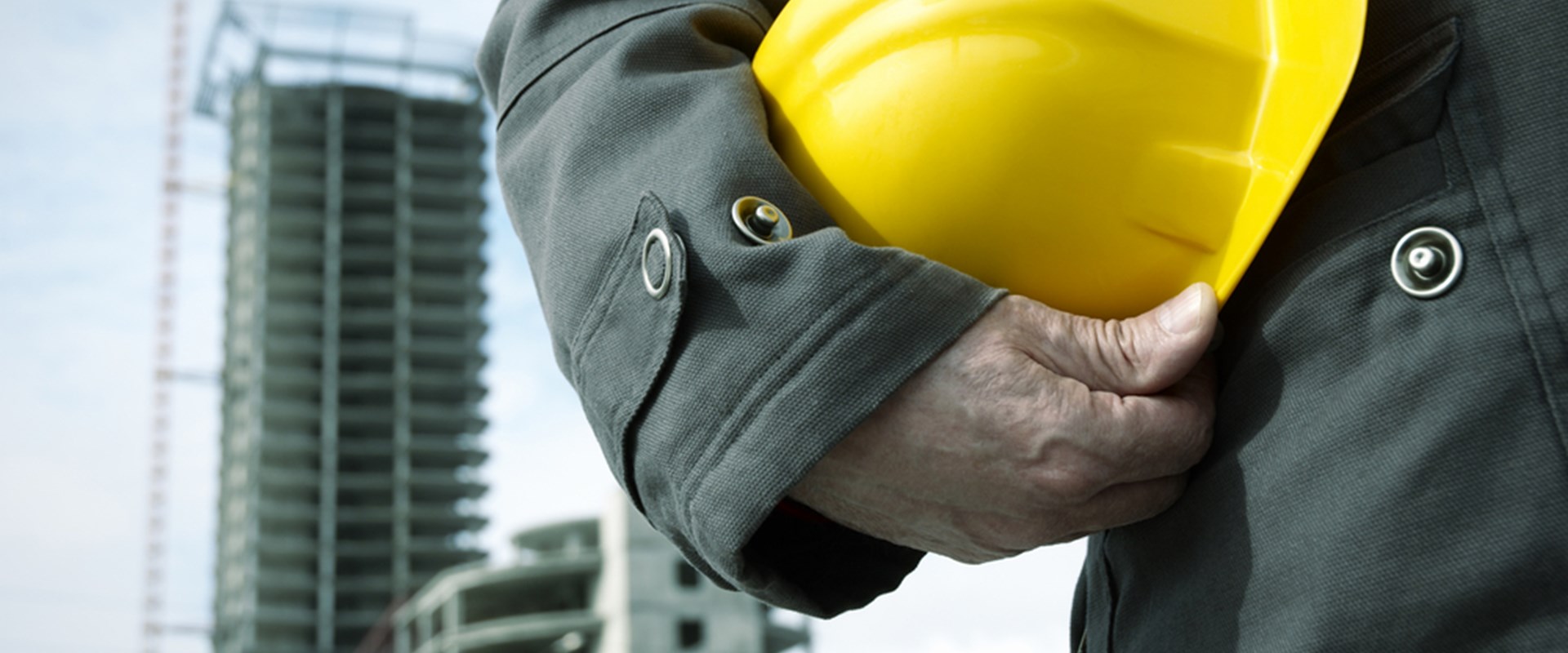 Engineer holding a helmet for workers security on background of building construction