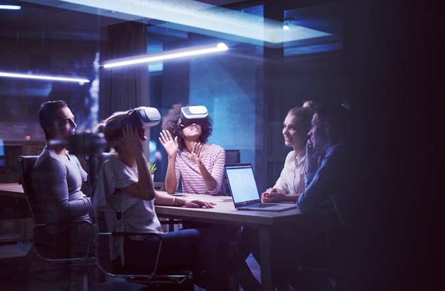 A group of people in a meeting using virtual reality headsets