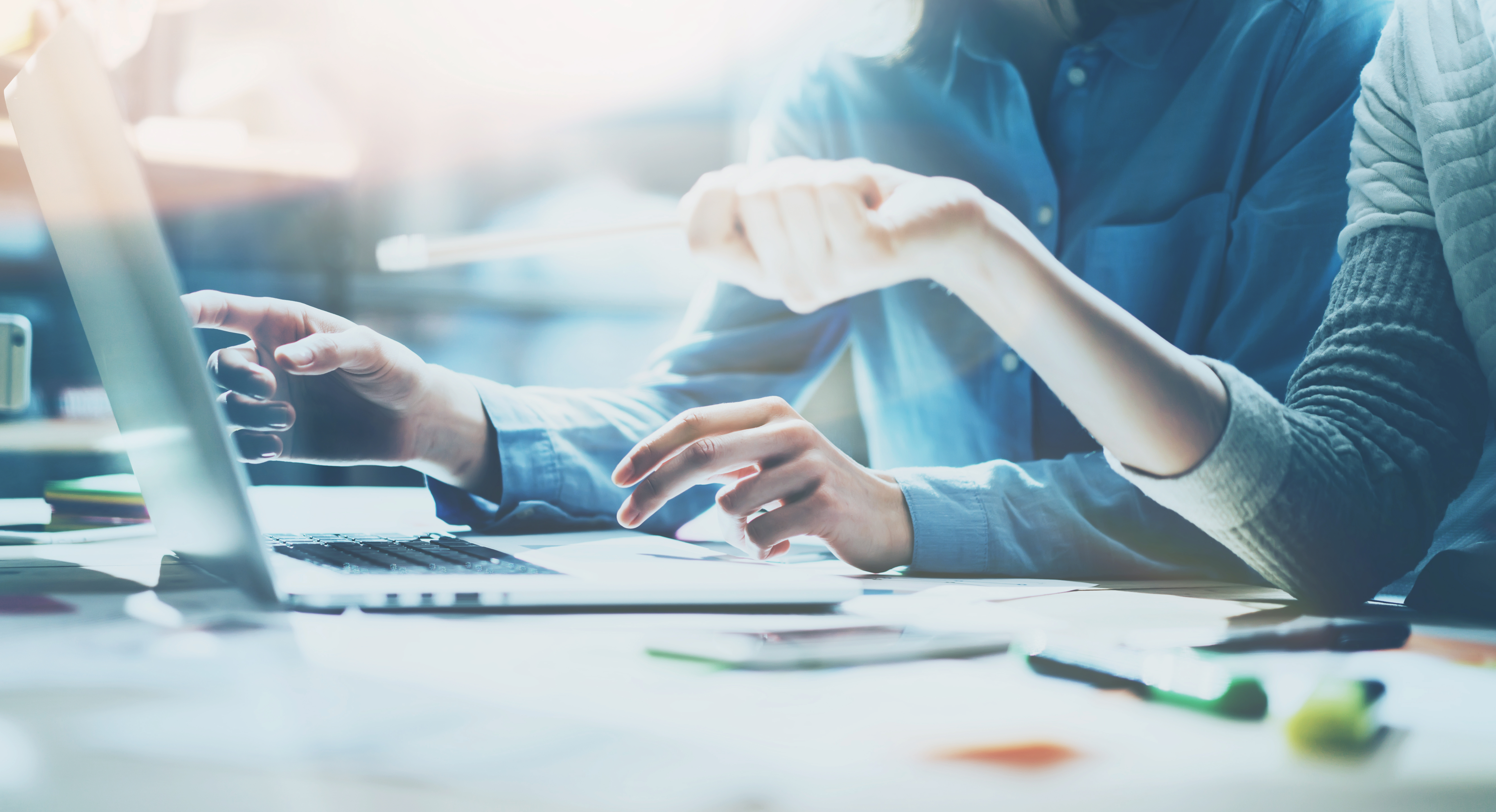 An image of people working at a desk looking at their computers