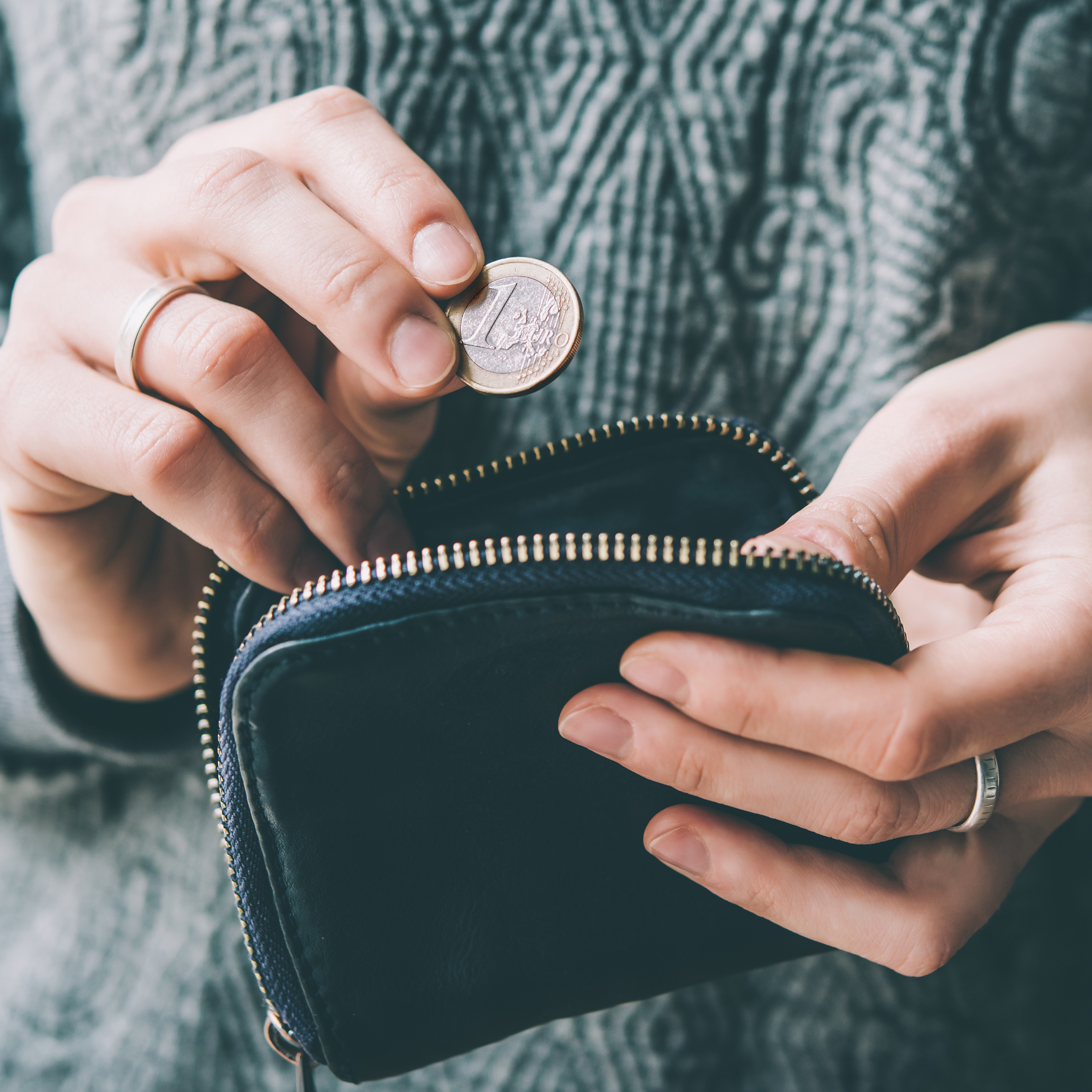 Lady putting money in to a black purse