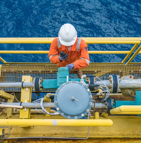 A BMT employee working on a monitoring system onboard an oil and gas rig