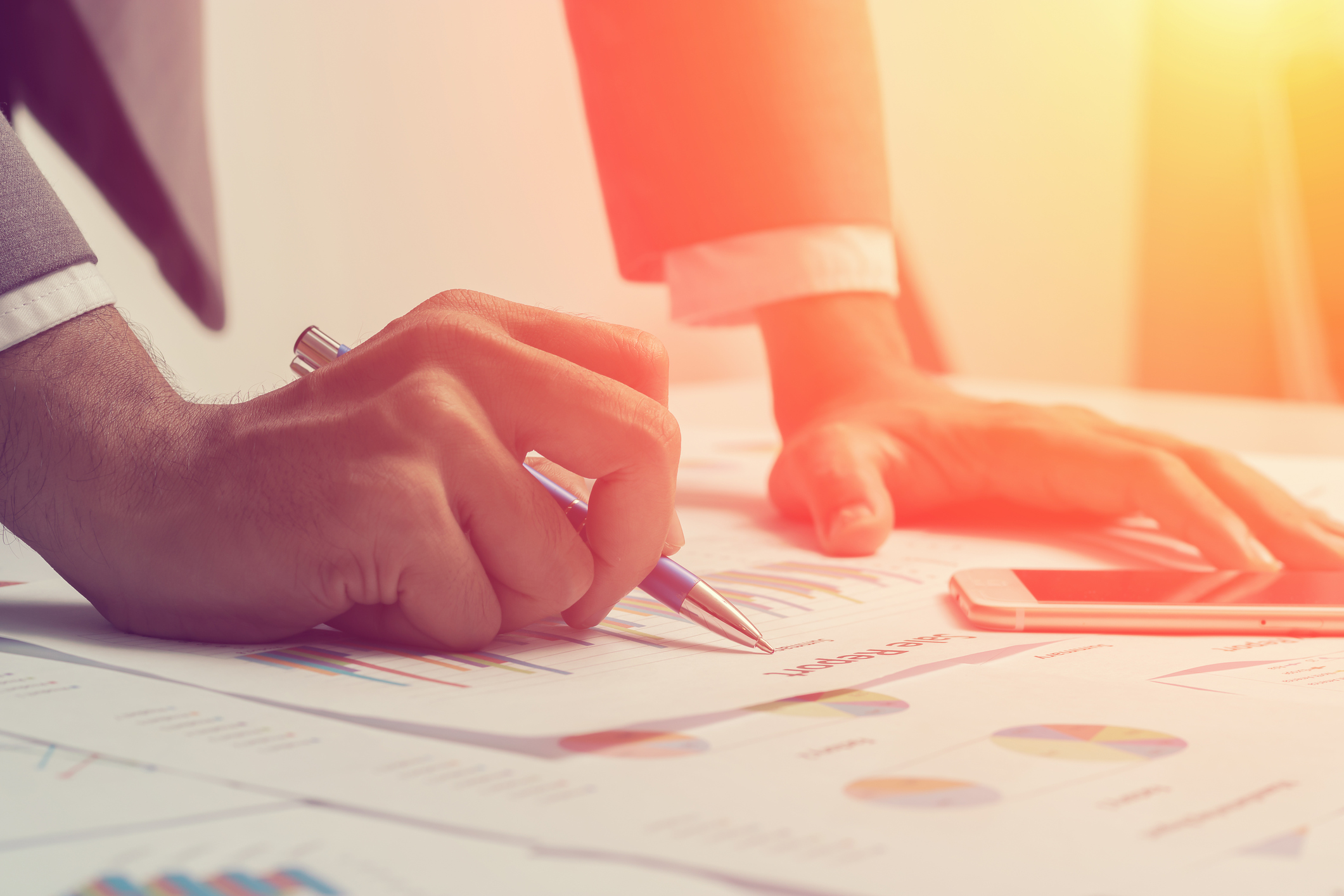 Image of man looking at printed spreadsheets on a desk