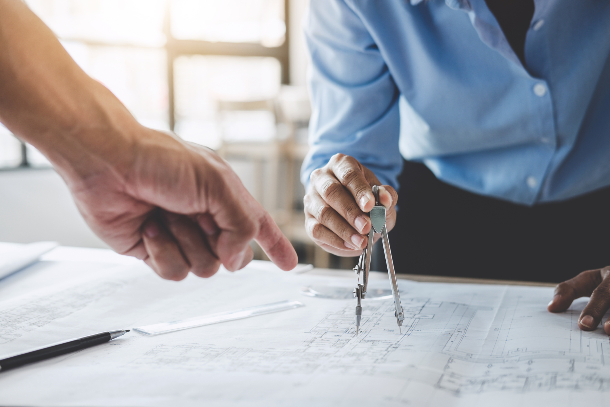 Image of two people looking at plans on a desk