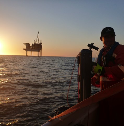 Sunset image of offshore platform with workers in the foreground