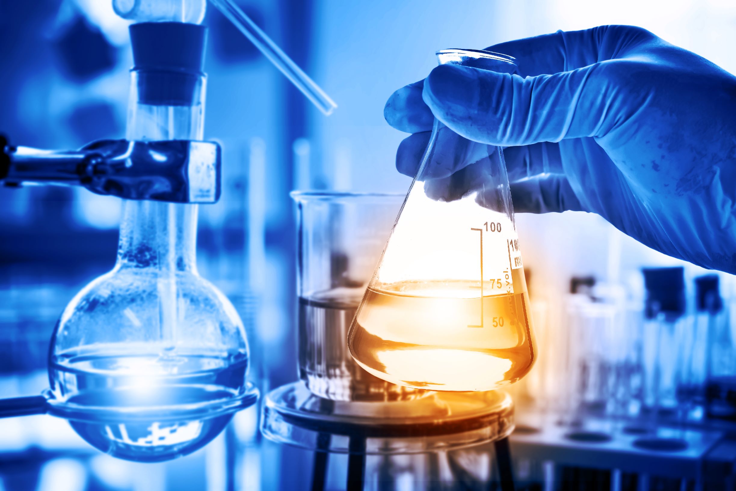 An image of a man holding a tube with liquid in a lab