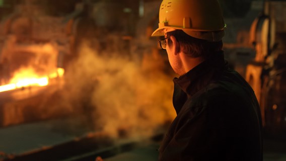 Image of a fire inspector looking over a live industrial fire