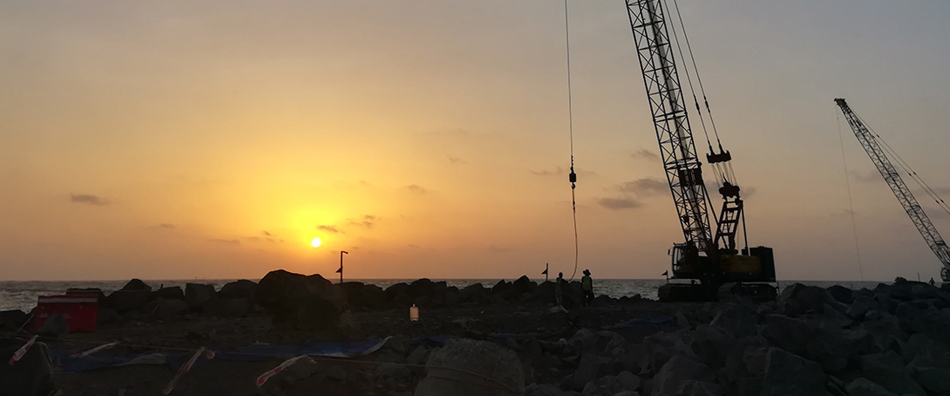 Construction crane in sunset silhouette