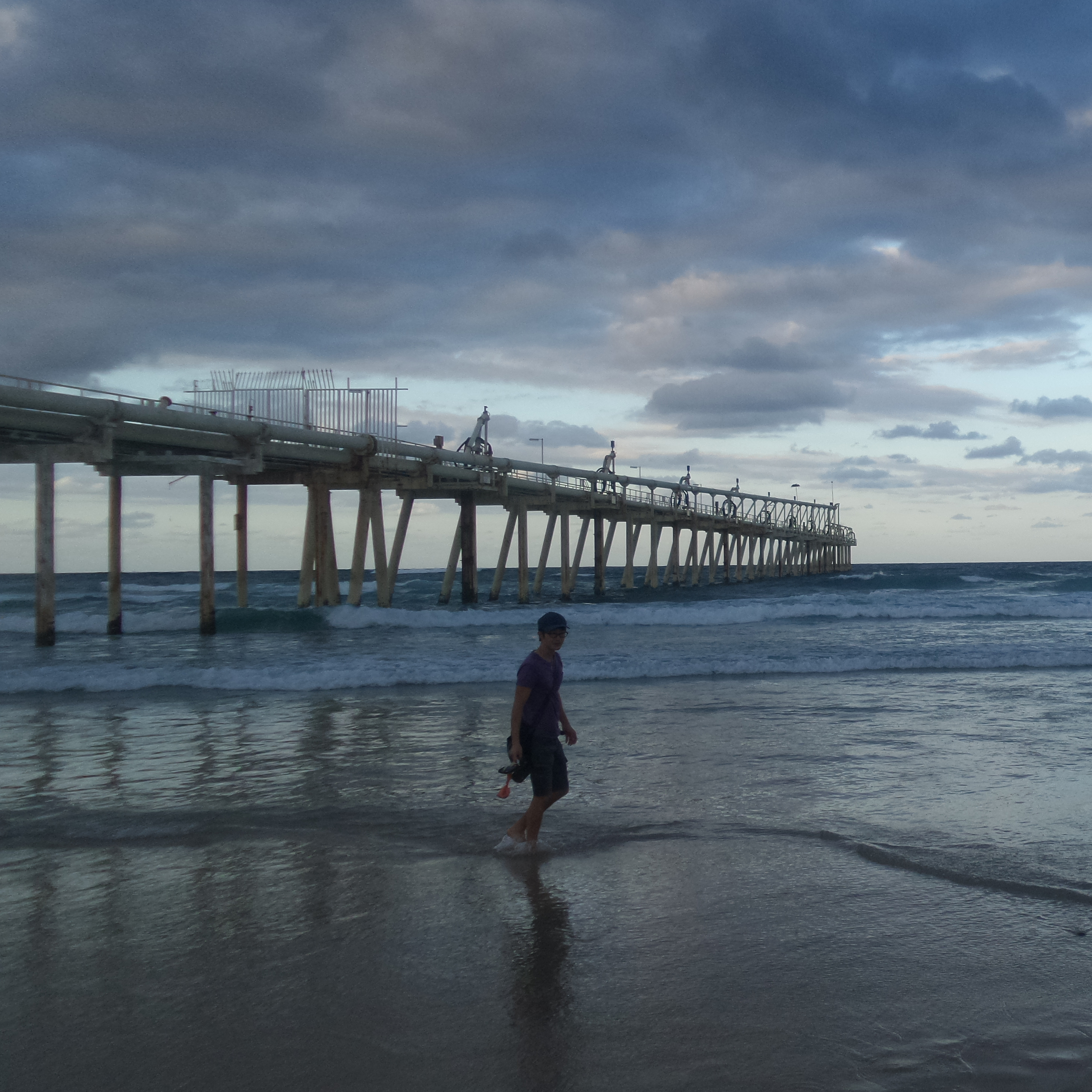 Man walking along sandy beach