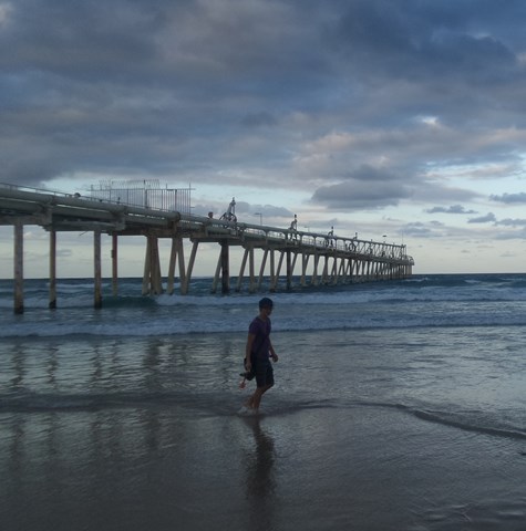 Man walking along sandy beach
