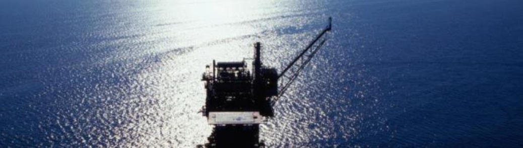 Offshore rig in sunlight with deep blue sea background