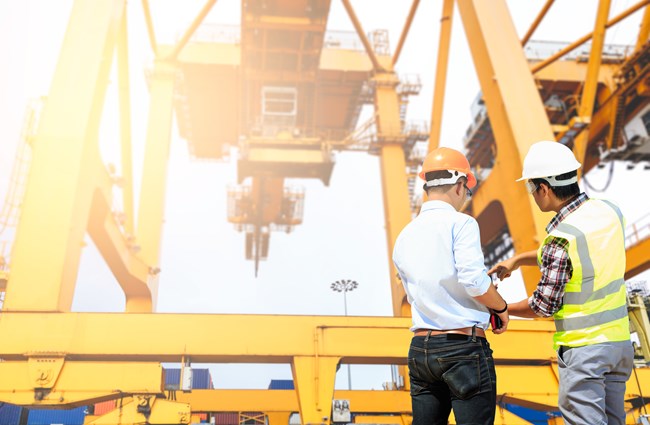 Engineers inspecting cargo lists at a port