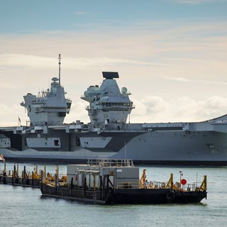 An image of the Queen Elizabeth Aircraft Carrier in Portsmouth harbour which will use BMT's REMBRANDT tug simulator for training