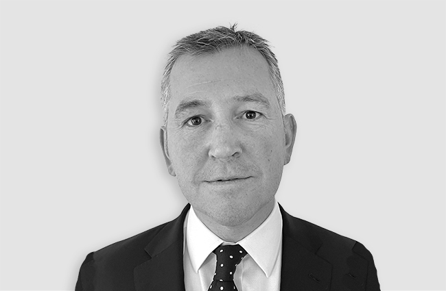 Head and shoulders shot of Gareth Taylor wearing a suit and tie