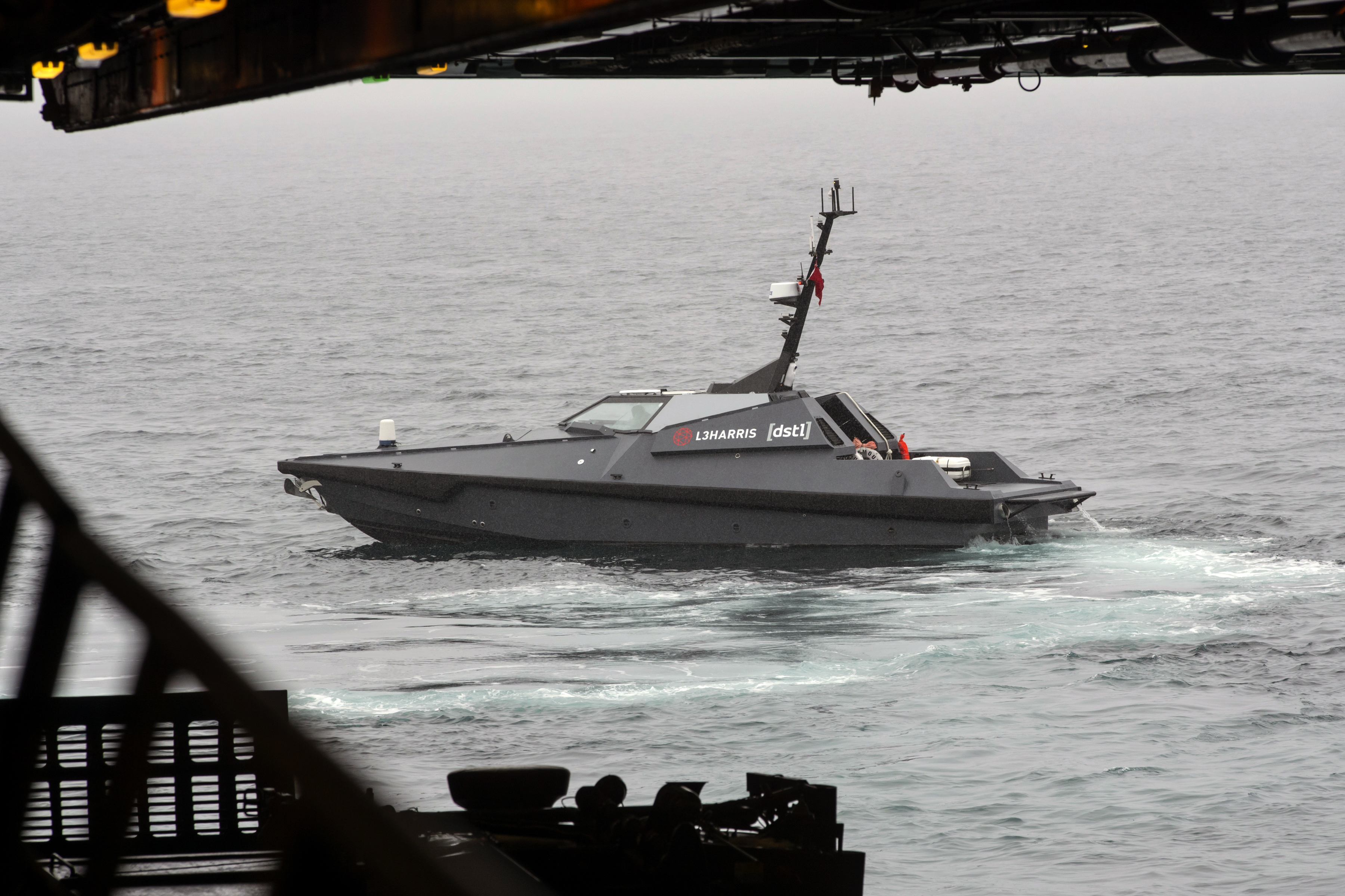 Photograph of Madfox Autonomous Surface vehicle, using the BMT REMBRANDT software.  Boat floating in calm waters. 